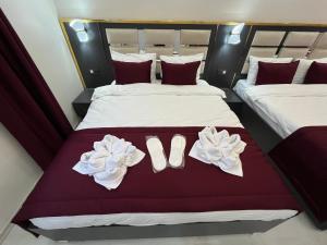 Lale Sultan Hotel في إسطنبول: سريرين في غرفة الفندق مع حذاء ومناشف