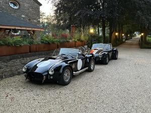 two black and white cars parked on a street at Jacuzzi - Sauna - BBq - Jardin - Garden Lodge - Myosotis in Olne