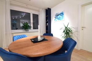 a dining room with a wooden table and blue chairs at “Opera House” Apartment Graz - Self Check-In in Graz