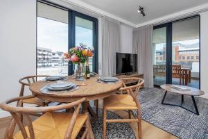 a dining room with a table with chairs and a television at Rooftop with breathtaking views of Table Mountain. in Cape Town