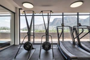 um ginásio com duas passadeiras e uma grande janela em Rooftop with breathtaking views of Table Mountain. na Cidade do Cabo