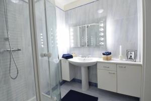 a white bathroom with a sink and a shower at “Opera House” Apartment Graz - Self Check-In in Graz