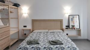 Un dormitorio con una cama con dos sombreros. en ALGAR LOFT, diseño y climatización, en Callosa de Ensarriá