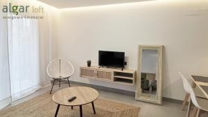sala de estar con TV y espejo en ALGAR LOFT, diseño y climatización, en Callosa de Ensarriá