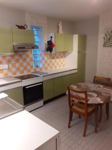 a kitchen with green cabinets and a table with a chair at Wenceslas Cobergher IV in Bertem