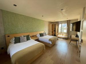 ein Hotelzimmer mit 2 Betten und einem Schreibtisch in der Unterkunft Boutique Hotel Durango219 in Mexiko-Stadt