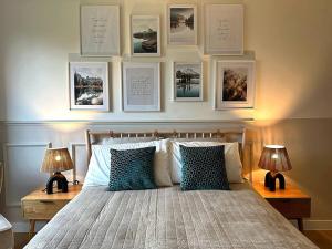 a bedroom with a bed with two lamps and pictures on the wall at Vick's house in Uxbridge