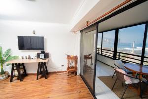 ein Wohnzimmer mit einem Schreibtisch und einem Tisch in der Unterkunft Departamento grande frente a playa Cavancha in Iquique