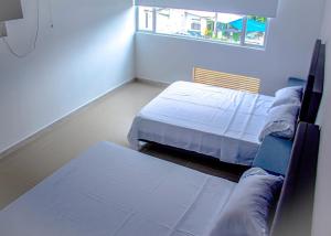 a room with two beds and a window in it at Plaza Real Edificio Turístico in Melgar