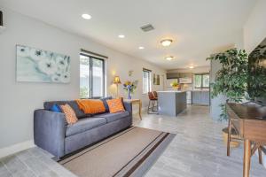 uma sala de estar com um sofá azul e uma cozinha em Sunny Florida Retreat Near Casinos, Walk to Beach! em Pompano Beach