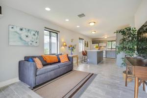 a living room with a blue couch and a kitchen at Walk to Flagler Beach Sunny Retreat Near Casinos in Pompano Beach