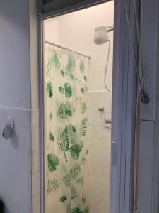 cortina de ducha con hojas en el baño en Quartos em Copacabana, en Río de Janeiro