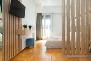 a bedroom with a bed and a television on a wall at KUKAKI ESTATE 2 in Athens