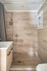 W łazience z drewnianymi ścianami znajduje się prysznic. w obiekcie KUKAKI ESTATE 2 w Atenach