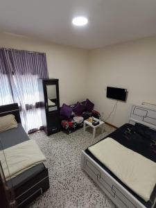une chambre d'hôtel avec deux lits et un canapé dans l'établissement Admf#101, à Abu Dhabi