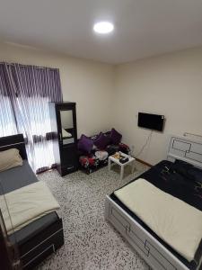 una habitación de hotel con dos camas y un sofá en Admf#101, en Abu Dabi