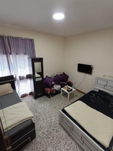 Un dormitorio con dos camas y un sofá. en Admf#101, en Abu Dabi