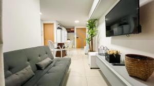 a living room with a couch and a flat screen tv at Eco Summer Tambaú - Apartamentos de 2 Quartos por Genius Flats in João Pessoa