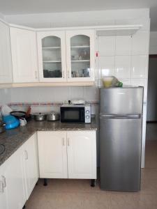 a kitchen with white cabinets and a stainless steel refrigerator at PRIME ALOJAMNETOS 01 in Gondomar