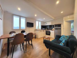ein Wohnzimmer mit einem Sofa und einem Tisch sowie eine Küche in der Unterkunft Le Bellevue - Beaux appartements avec vue splendide in Palaiseau