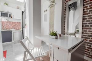 ein weißes Esszimmer mit einem weißen Tisch und Stühlen in der Unterkunft Cozy studio next to Canal Saint-Martin in Paris