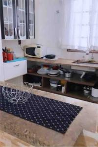 uma cozinha com um lavatório e uma bancada em Seu Cantinho na Vila Tupi 3 Dormitórios na Praia Grande