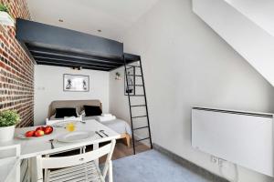 Zimmer mit einem Bett und einem Tisch mit einer Obstschale in der Unterkunft Cozy studio next to Canal Saint-Martin in Paris