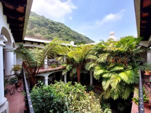 un balcón de un edificio con palmeras y una montaña en Hotel Casa Búho B&B, en Antigua Guatemala