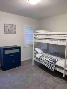 a bedroom with two bunk beds and a blue dresser at Modern & Cozy Kawartha Getaway in Kawartha Lakes