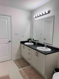 ein Badezimmer mit zwei Waschbecken und einem großen Spiegel in der Unterkunft Modern & Cozy Kawartha Getaway in Kawartha Lakes