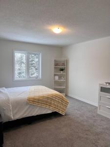Schlafzimmer mit einem Bett und einem Fenster in der Unterkunft Modern & Cozy Kawartha Getaway in Kawartha Lakes