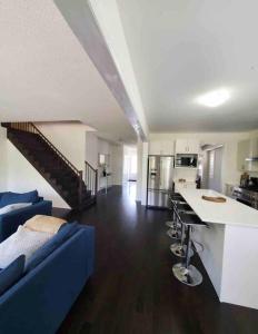 ein Wohnzimmer mit einem blauen Sofa und einer Küche in der Unterkunft Modern & Cozy Kawartha Getaway in Kawartha Lakes
