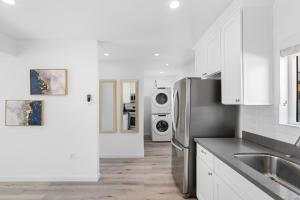 a kitchen with a refrigerator and a washer and dryer at Miracle Mile Chic Bungalow with Parking 3 in Los Angeles