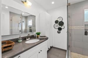 a white bathroom with a sink and a shower at Miracle Mile Chic Bungalow with Parking 3 in Los Angeles