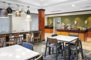 パデューカにあるFairfield Inn & Suites by Marriott Paducahのテーブルと椅子のあるレストラン、キッチンが備わります。
