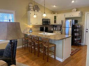 eine Küche mit einer Insel mit einer Spüle und einem Kühlschrank in der Unterkunft Phoenix Nest Guest Houses - Sunday House in Llano