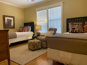 1 Schlafzimmer mit 2 Betten, einem Stuhl und einem Fenster in der Unterkunft Phoenix Nest Guest Houses - Sunday House in Llano