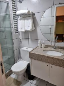 uma casa de banho com um WC, um lavatório e um espelho. em Gran Lençóis Flat Residence em Barreirinhas