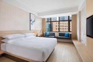a bedroom with a white bed and a large window at Fairfield by Marriott Shanghai Pudong Central in Shanghai