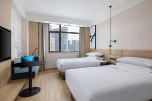a hotel room with two beds and a flat screen tv at Fairfield by Marriott Shanghai Pudong Central in Shanghai