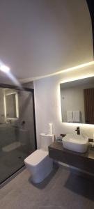 y baño con aseo, lavabo y espejo. en Casa Tlaxcalli by Beddo Hoteles en Tlaxcala de Xicohténcatl