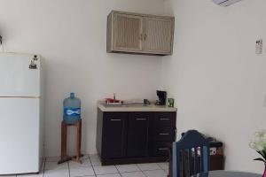 a kitchen with a sink and a refrigerator at Casa Laguna Milagros, a 20 minutos de Bacalar in Chetumal