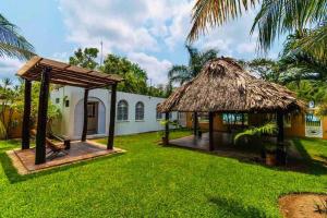 una casa con techo de paja y patio en Casa Laguna Milagros, a 20 minutos de Bacalar, en Chetumal