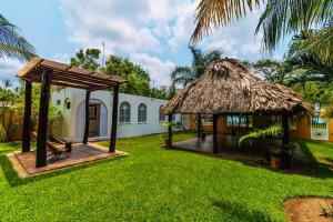 a house with a thatched roof and a yard at Casa Laguna Milagros, a 20 minutos de Bacalar in Chetumal