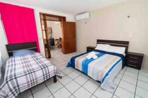 1 dormitorio con 2 camas en una habitación en Casa Laguna Milagros, a 20 minutos de Bacalar, en Chetumal