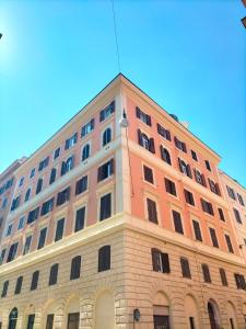 un grand bâtiment rose avec des fenêtres au-dessus dans l'établissement Charming Colosseum apartment, à Rome