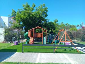 a playground with a slide and a play structure at Villas Dulce Suenos in Rincon de Guayabitos