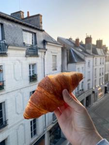 una persona sosteniendo un pedazo de pan en Magnifique logement au pied du Château en Blois