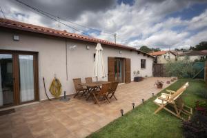 a patio with a table and chairs next to a house at Casa Regente in O Viso +9 photos