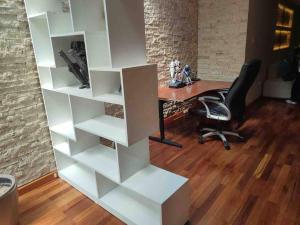 an office with a desk and a chair and white shelves at No está disponible in Arequipa